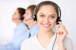 © rogerphoto - Call center operators. Young beautiful business woman in headset.  Male phone operator in headset at the background.