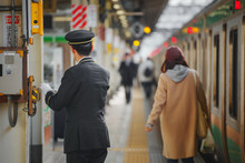 Unidentified Japanese Train Conductor At A Train Station In Tokyo, Japan
