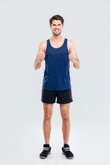 Wall Mural - Full length portrait of a fitness man showing thumb up