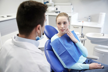 Canvas Print - male dentist with woman patient at clinic