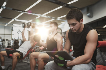 Wall Mural - group of men with tablet pc and dumbbells in gym