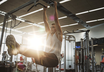 Poster - man flexing abdominal muscles on pull-up bar