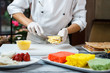 © DenisProduction.com - Hands putting custard on shortcake. Man prepares dessert at table. Sweet and dense filling. Pastry chef at local restaurant.
