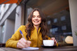 © Syda Productions - happy woman with notebook drinking cocoa at cafe