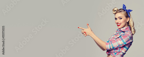 Photo  woman, dressed in pin-up style, showing something or copyspace