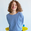 © kegfire - Hipster girl holding a vivid color skateboard