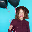 © kegfire - girl in fashion clothes holding colored black balloons