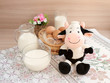 Молоко в стеклянной посуде и куриные яйца на завтрак. Смешная игрушечная корова символизирует молочную продукцию.