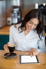 Wall Mural - Close-up of businesswoman using digital tablet in café