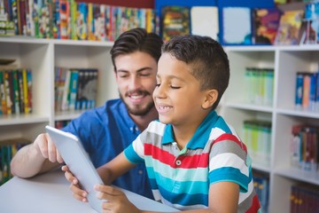teacher and school kid using digital table in library
