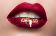 Leinwandbild Motiv Beautiful female lips closeup. Red lipstick, gold paint flowing over his lips. Stock Photo Cosmetic Advertising