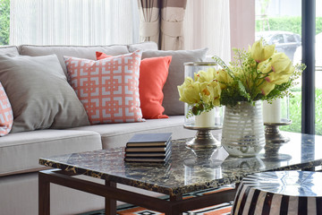 Books and decorative items on marble top table and lively sofa set