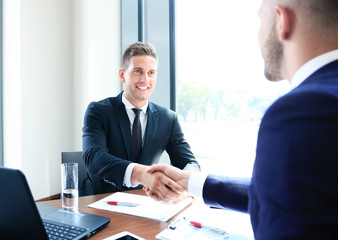 Two business colleagues shaking hands during meeting