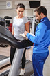 © sasamihajlovic - Fitness instructor writing program to his client on a treadmill