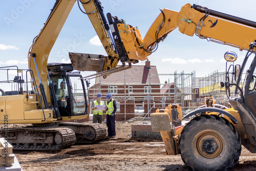 Fototapeta Builders with machinery on housing building site