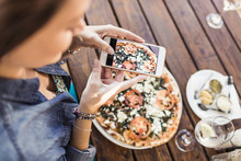 Woman Taking Pictures Of Pizza