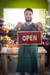 © WavebreakmediaMicro - Male florist holding open signboard at his flower shop