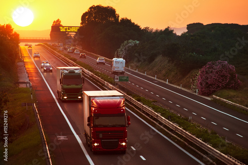 Obraz Dibond ciężarówki na autostradzie o zachodzie słońca
