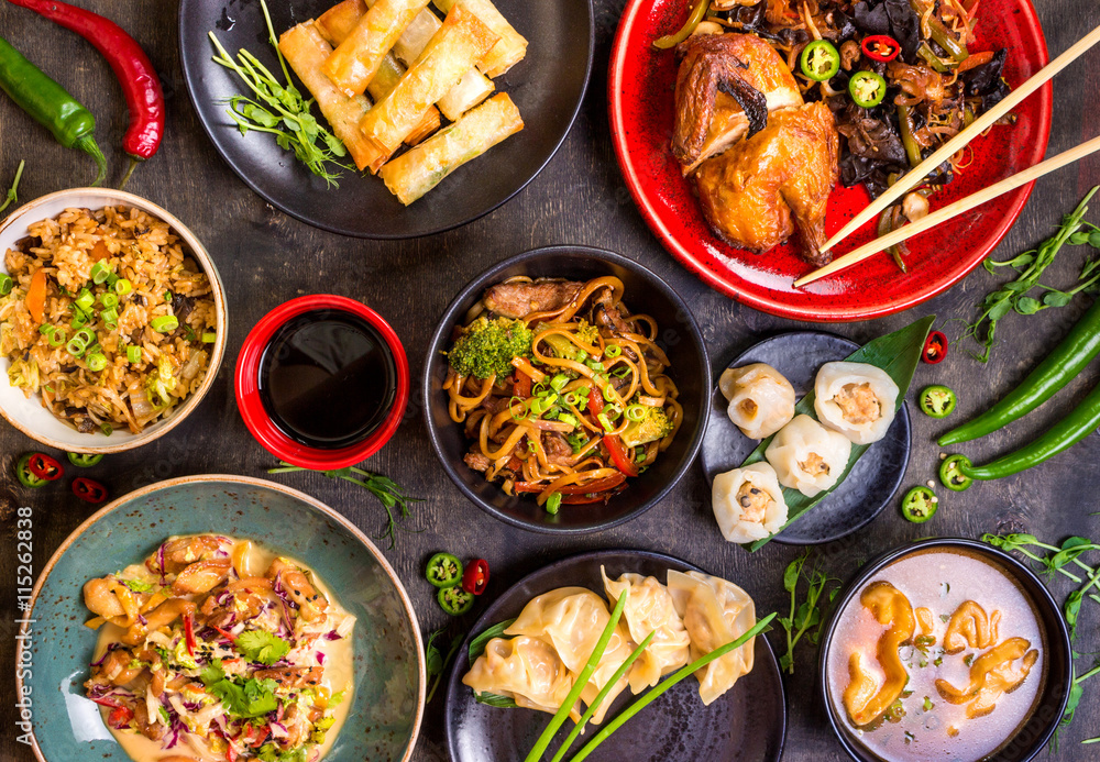 Assorted Chinese food set. Chinese noodles, fried rice, dumplings, peking duck, dim sum, spring rolls. Famous Chinese cuisine dishes on table. Top view. Chinese restaurant concept. Asian style banquet - obrazy, fototapety, plakaty 