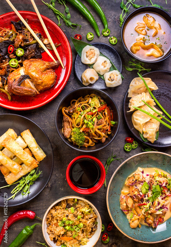 Assorted Chinese food set. Chinese noodles, fried rice, dumplings, peking duck, dim sum, spring rolls. Famous Chinese cuisine dishes on table. Top view. Chinese restaurant concept. Asian style banquet © somegirl