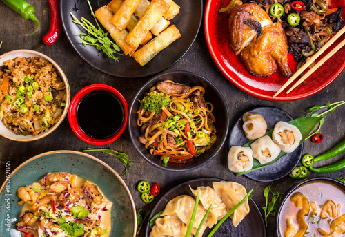 Assorted Chinese food set. Chinese noodles, fried rice, dumplings, peking duck, dim sum, spring rolls. Famous Chinese cuisine dishes on table. Top view. Chinese restaurant concept. Asian style banquet © somegirl