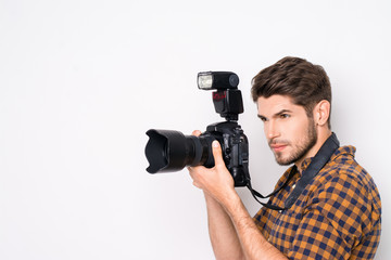 Portrait of young handsome professional photographer taking phot