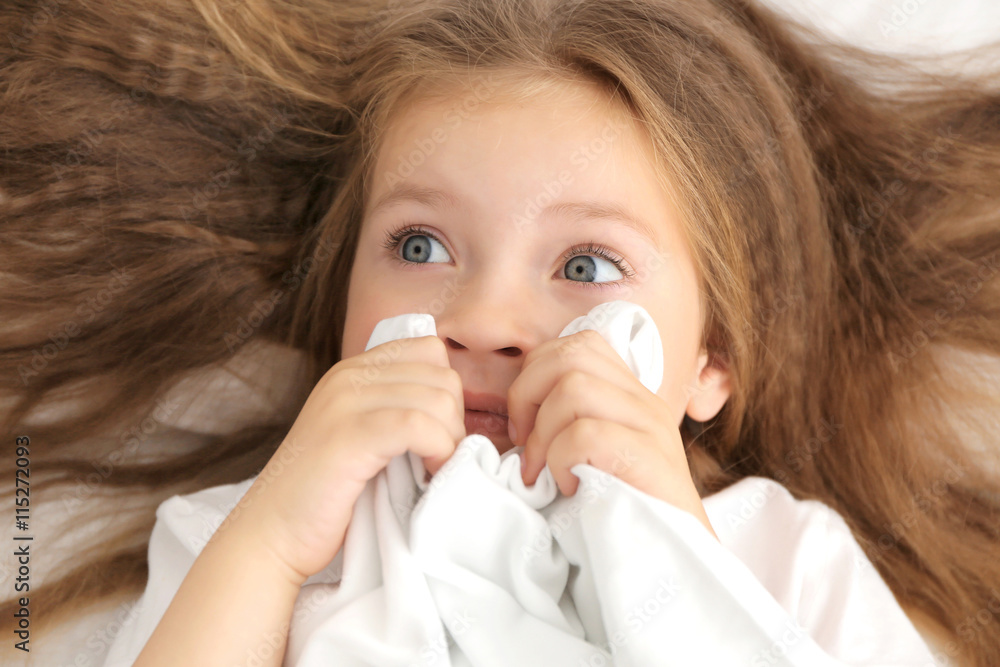 Cute little girl holding sheet in hands, close up
