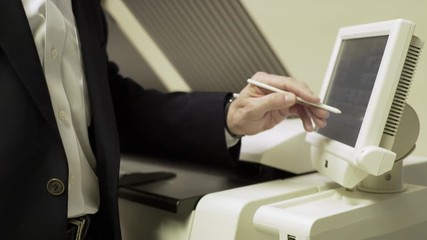 businessman pressing the touch screen of a large printer 4k