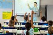 © WavebreakmediaMicro - Teacher teaching schoolchildren using projector screen