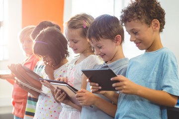 smiling children using digital tablets