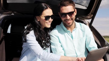 Poster - happy couple with tablet pc at hatchback car trunk 3