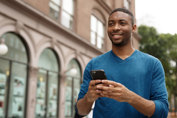 Canvas Print - Young man in city texting cell phone