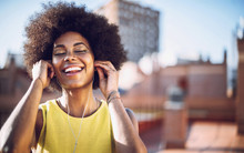 Young Afro Woman Listen To Music With Headphones On The Rooftop