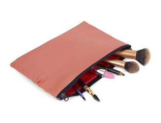 Wall Mural - A cosmetic bag with make up and brushes spilling out, isolated on a white background