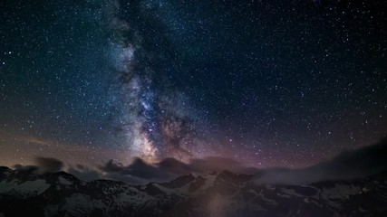 Wall Mural - the apparent rotation of an outstandingly bright milky way and the starry sky beyond snowcapped moun