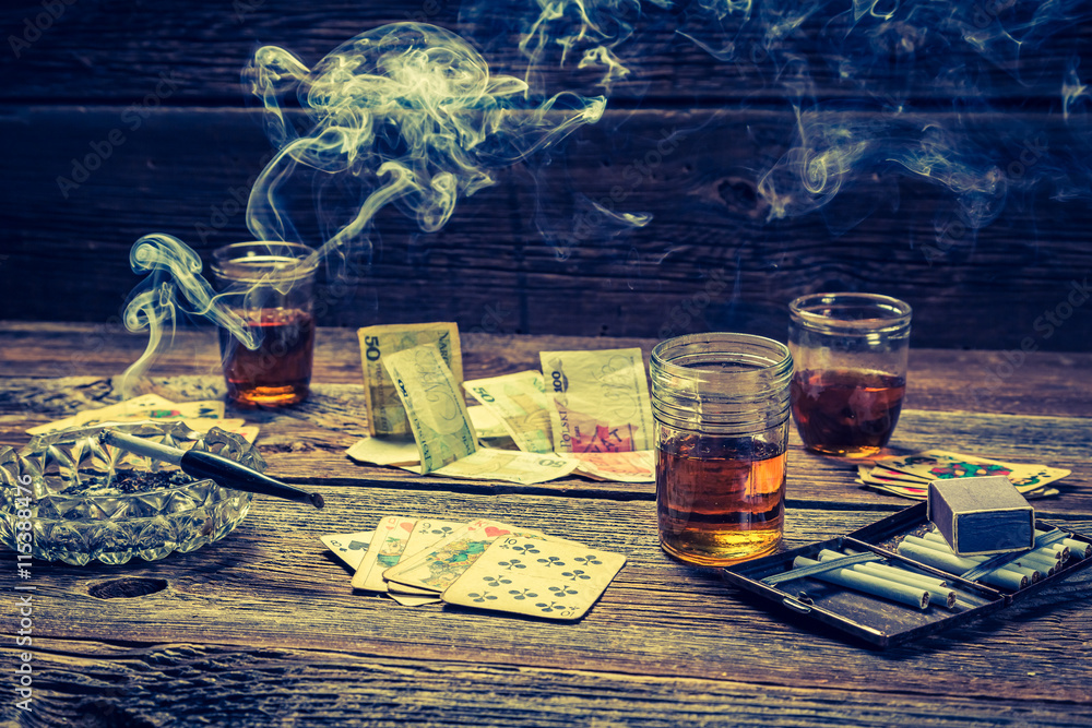 cigarettes and vodka Vodka, cigarettes and cards on old illegal gambling table Stock Photo