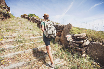 Wall Mural - Hiker traveler woman on a walking route, travel and active lifestyle concept