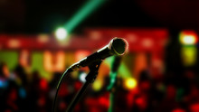 Microphone On Stage Ready For Performer With Full Audience Blurred Background