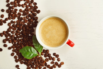 Poster - Cup of coffee with beans and leaves on light background