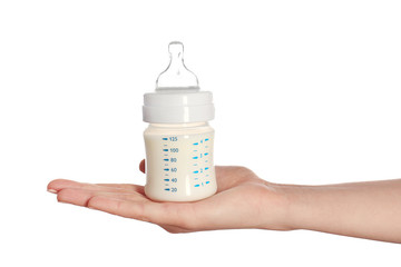 Fototapete - Female hand holding a baby bottle of milk on white background