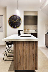 Modern kitchen countertop with a wall watch and chairs