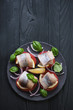 Top view of canapes with herring on a black wooden surface