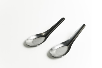 used two asian silver table spoons on white background