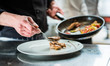 Koch richtet Essen auf Teller an in Restaurant oder Hotel Küche