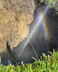 The water jet in the form of leakage in the damaged metal pipe at the production site