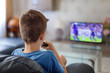 © sakkmesterke - Excited little kid watching soccer match in TV