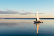 Sailing Boat On A Calm Lake With Reflection