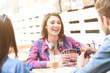 © Yakobchuk Olena - Friends playing card game while sitting at outdoor cafe