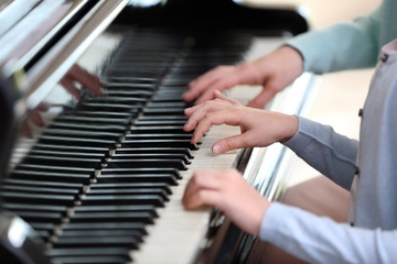 Wall Mural - Small girl learning play piano with teacher