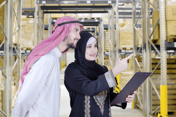 Wall Mural - Two Arabian workers look at warehouse